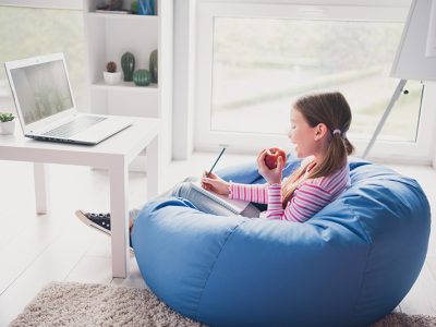 Full size photo of small cute daughter remote education sit bean bag home schooling eat apple isolated indoors.